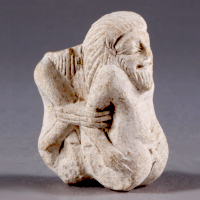 An Egyptian Limestone Gaming Piece Showing Two Asiatic Prisoners
